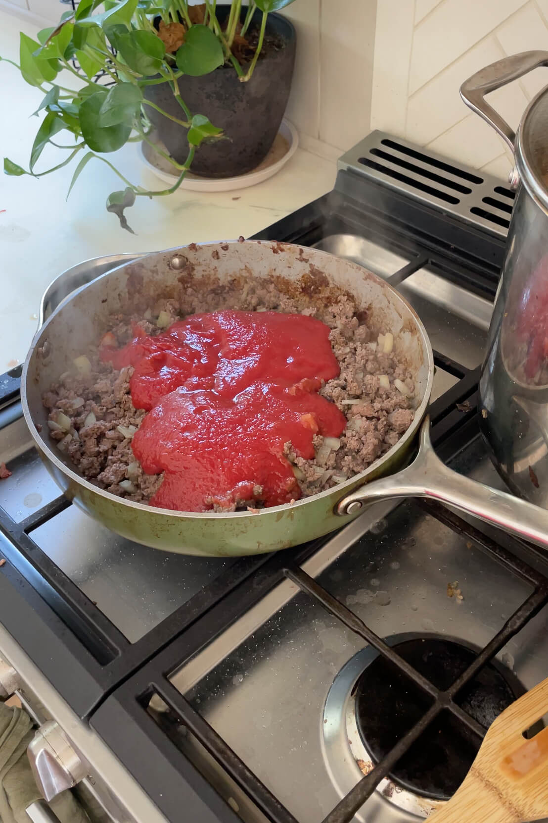 Adding tomato sauce to chili.